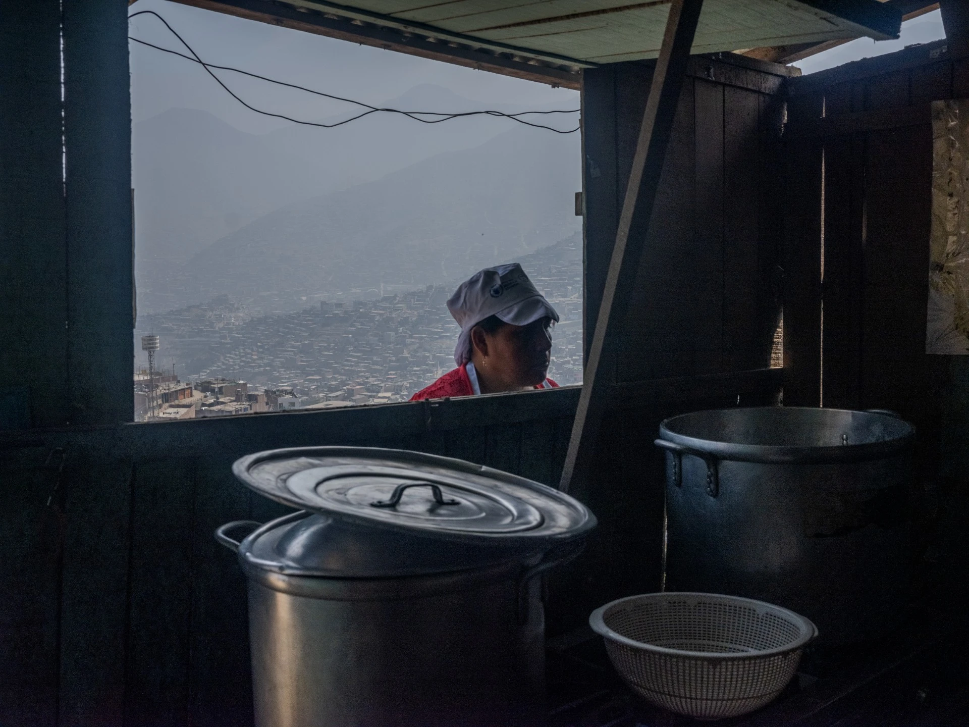 Usuaria de las ollas comunes observando dos ollas mientra preparan los alimentos.