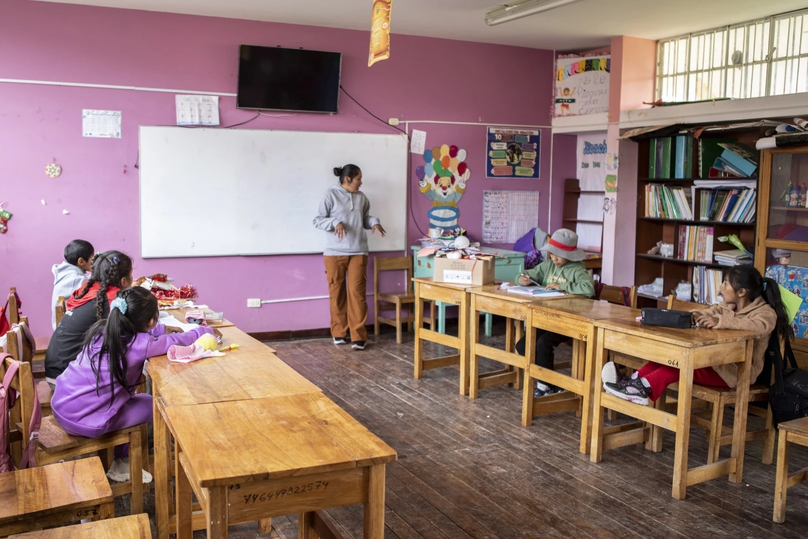 Salón de clases con niños y un profesora.