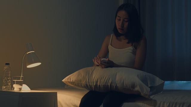beautiful-asian-young-woman-sitting-on-bed-take-sleeping-pill-or-night-medicine-in-bedroom-unhealthy-sick-indian-female-suffers-from-insomnia-or-headache-depressed-girl-holds-antidepressant-meds