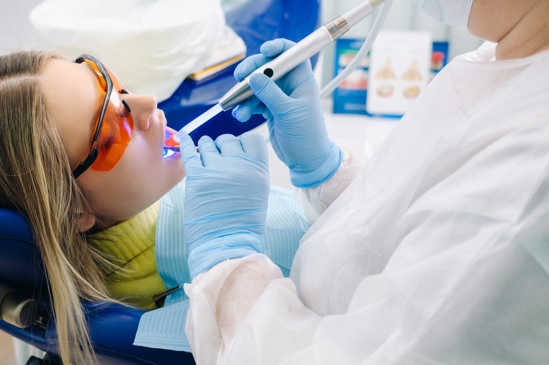 female-patient-in-dental-glasses-treats-teeth-at-the-dentist-with-ultraviolet-light-dental-fillings