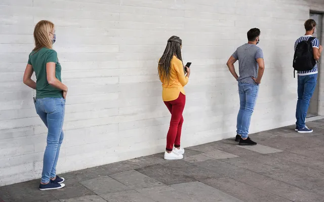 group-of-young-people-waiting-for-going-inside-shop-market-while-keeping-social-distance-in-line-during-coronavirus-time.jpg