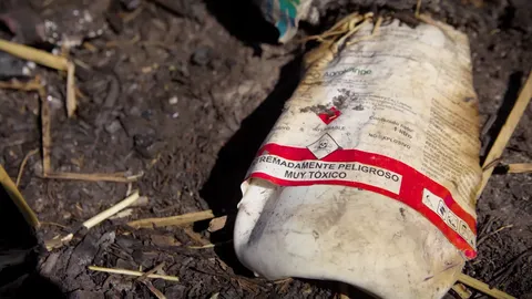 Frasco de pesticida de etiqueta roja que es extremadamente peligroso y muy tóxico.