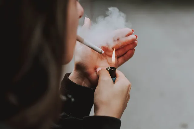 selective-closeup-shot-female-lighting-up-cigarette-with-lighter