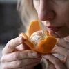 sick-woman-trying-to-sense-smell-of-fresh-tangerine-orange-has-symptoms-of-covid-19-corona-virus.jpg
