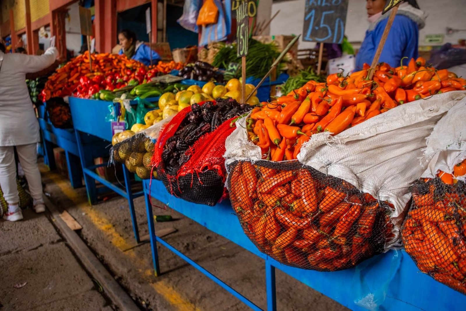 Un puesto de mercado con zanahorias, pimientos y otras hortalizas a la venta